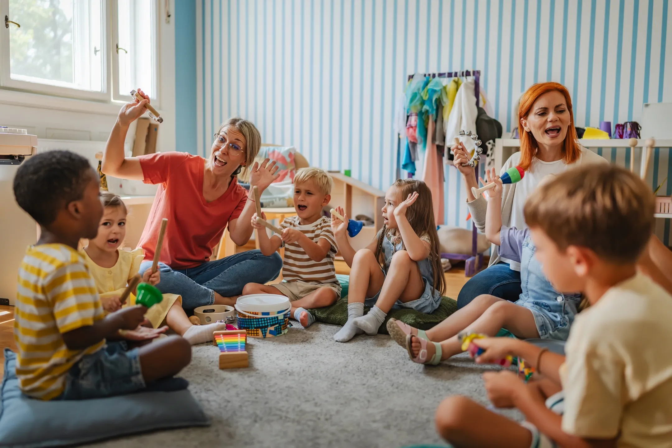 Diverse Vorschulkinder spielen mit Instrumenten im bunten Klassenzimmer
